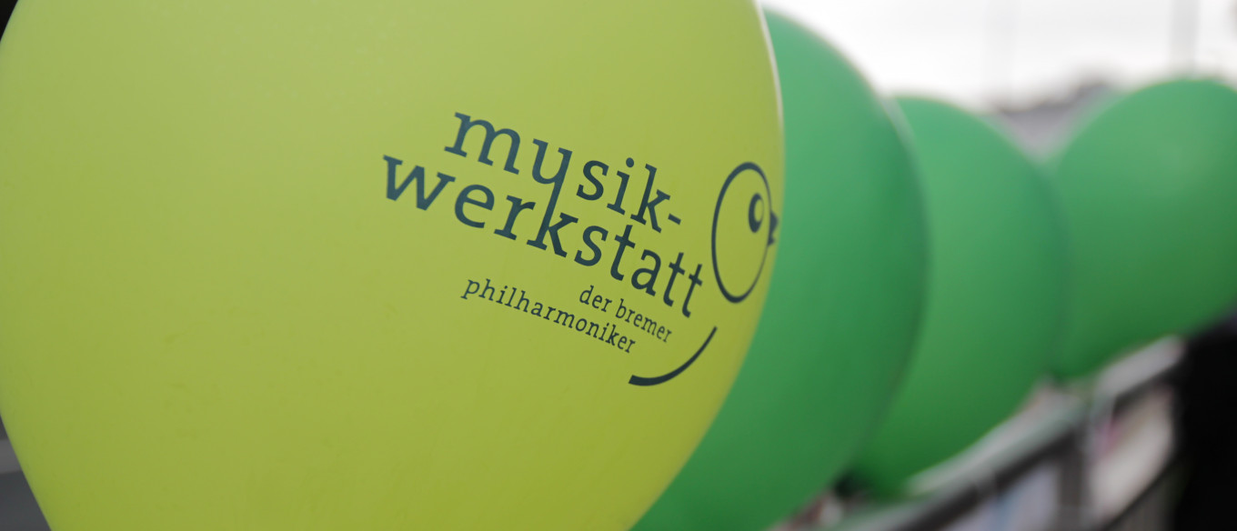 grüne Luftballons mit Musikwerkstatt Logo