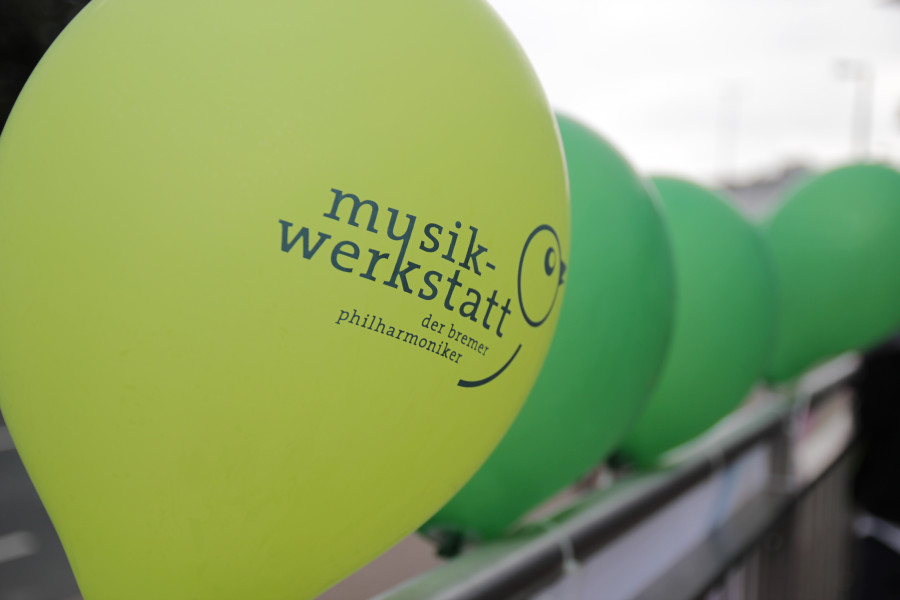 grüne Luftballons mit Musikwerkstatt Logo