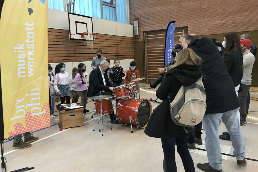 Bürgermeister Bovenschulte am Schlagzeug, umringt von Kindern und Presse
