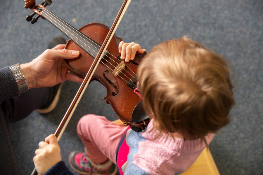 kleines Kind mit Geige von oben
